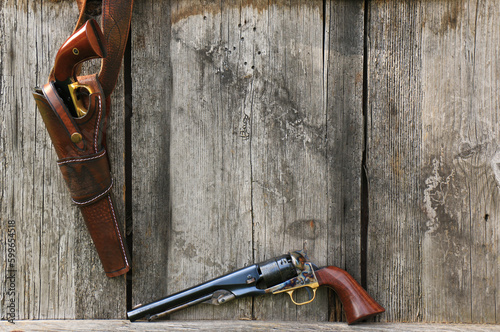 Two most famous Black powder revolvers Colt Army and Remington New Army (in a leather holster) on an old board background.