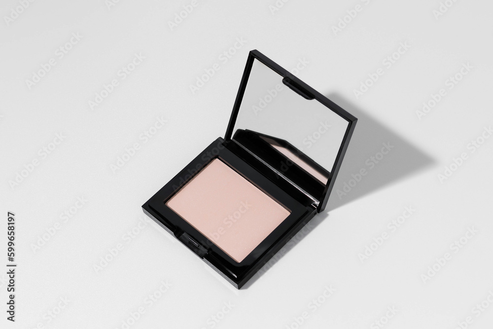 Pink or peach face powder with mirror with shadow from direct light on white isolated background. Concept of decorative cosmetics for face makeup, cosmetic product. Image for your design. Pink or peach face powder with mirror with shadow from direct light on white isolated background. Concept of decorative cosmetics for face makeup, cosmetic product. Image for your design.