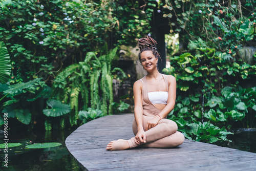 Portrait of cheerful female enjoying time for holistic healing duirn retreat vacations at Bali  happy woman 20 years old keeping healthy lifestyle resting during yoga training and smiling at camera