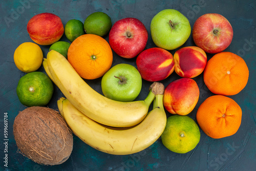 top view different fruit composition bananas tangerines apples on dark-blue desk fruit fresh mellow ripe color vitamine
