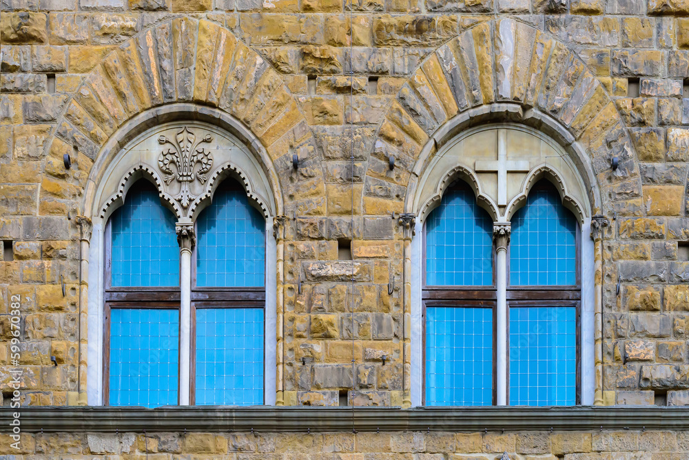 Facade of medieval building with traditional windows in Florence city, Tuscany, Italy. Сlose-up with details