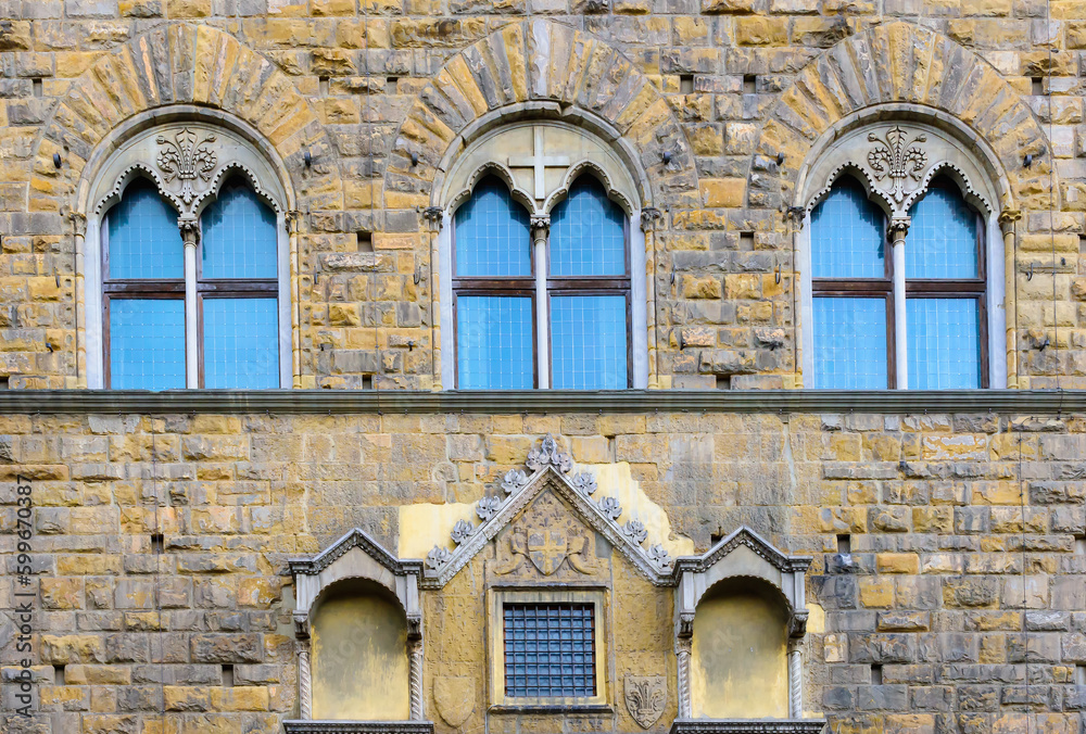 Facade of medieval building with traditional windows in Florence city, Tuscany, Italy. Сlose-up with details