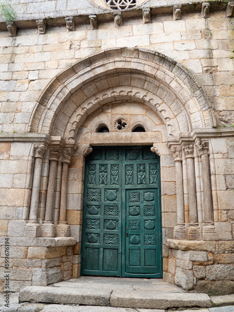 Green door with engravings of the parish church of Santiago, the oldest in Ribadavia in Romanesque style, visited in the summer of 2021 in Orense, Galicia, Spain.