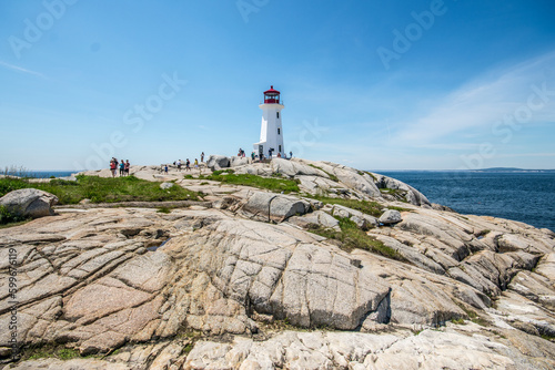 Lighthouse by sea against sky in Peggy's Cove, Nova Scotia.