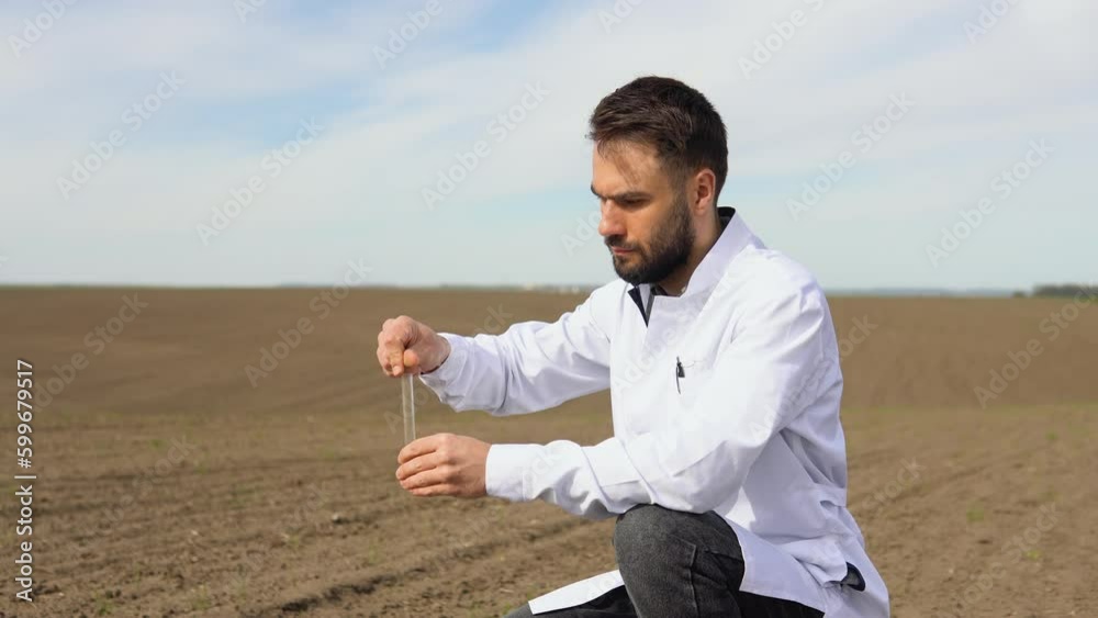 Laboratory worker holding professional glassware and testing black soil before harvest in the field