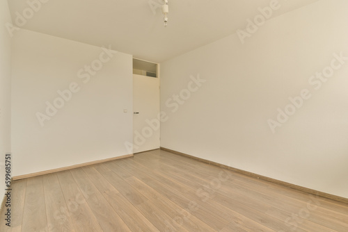 an empty room with white walls and wood flooring on the right  there is a ceiling fan in the corner