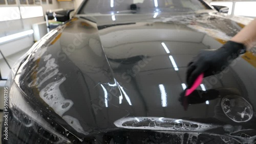 Close up to PPF installation process on a front headlight and hood. PPF is a Paint Protection Film which protect paint from scratches and stone chips. Concept of: Guard, Protect, Car, New, Work.	
