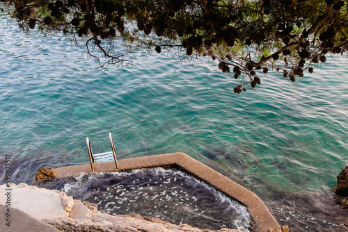 Croatia Dubrovnik. Swimming from the cliff. Stairs into the sea. Natural hot tub in the sea.