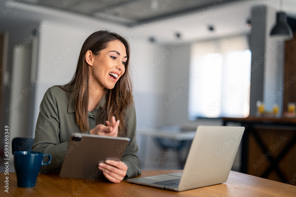 Serene young woman working on laptop at home office. Young female freelancer or remote teacher using laptop, remote studying, virtual training, participating in online education webinar at home office