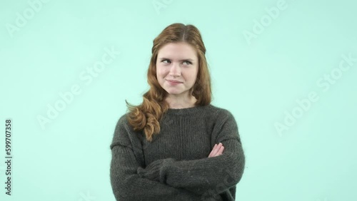 This portrait depicts an emotional girl making gestures. She is a funny Caucasian girl wearing a sweater and laughing while looking at the camera