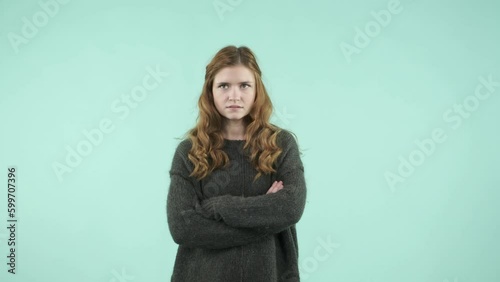 This portrait depicts an emotional girl making gestures. She is a funny Caucasian girl wearing a sweater and laughing while looking at the camera