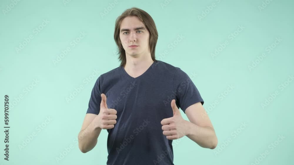 A young man with friendly manners and an emotional facial expression playfully interacts with the camera, dressed in a T-shirt and standing against an isolated background. A young man with friendly manners and an emotional facial expression playfully interacts with the camera, dressed in a T-shirt and standing against an isolated background.