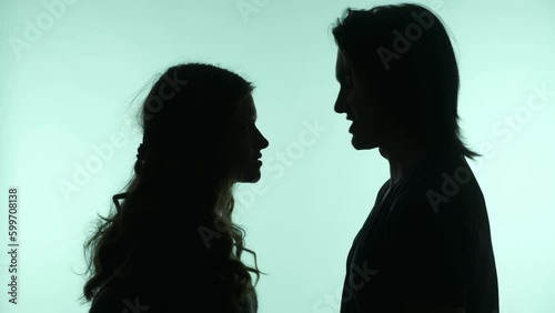 silhouette of a couple of girls and men looking at each other on a uniform background