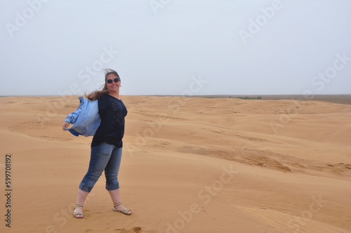Young woman stands in the desert in the wind © Anton