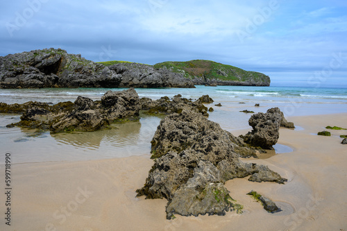 View on Playa de Borizo in Celorio, Green coast of Asturias, North Spain with sandy beaches, cliffs, hidden caves, green fields and mountains. photo