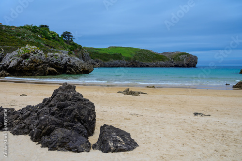 View on Playa de Borizo in Celorio, Green coast of Asturias, North Spain with sandy beaches, cliffs, hidden caves, green fields and mountains. photo