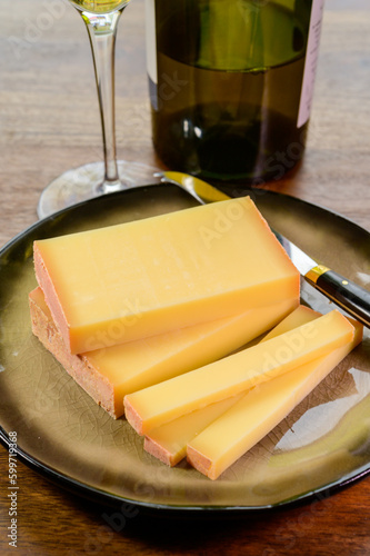 Wine and cheese pairing, local Comte cheese produced in the Franche-Comte region and special and characteristic yellow wine vin jaune from Jura region, France photo