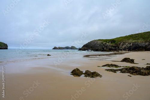View on Playa de Borizo in Celorio  Green coast of Asturias  North Spain with sandy beaches  cliffs  hidden caves  green fields and mountains.