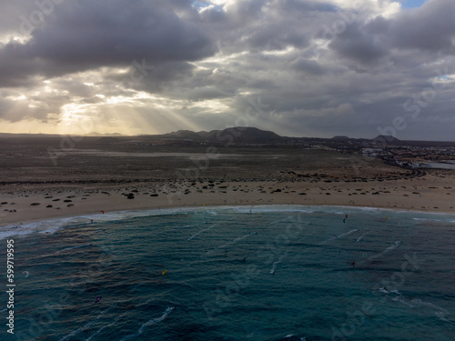 Aerial view on white sandy Corallejo dunes  beach  ocean water and kite surfers at winter