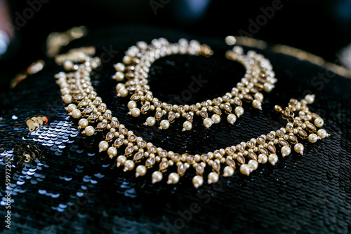 Indian bride's beautiful wedding jewelry decorated with pearls on black surface
