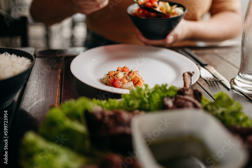 Churrasco - Barbecue Rodizio - Serving vinaigrette, rice, farofa and skewers