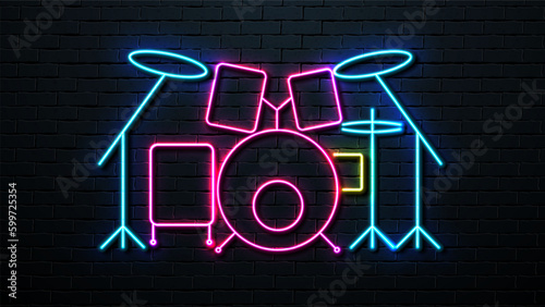 Neon drum kit on the background of a brick wall. Retro signboard.