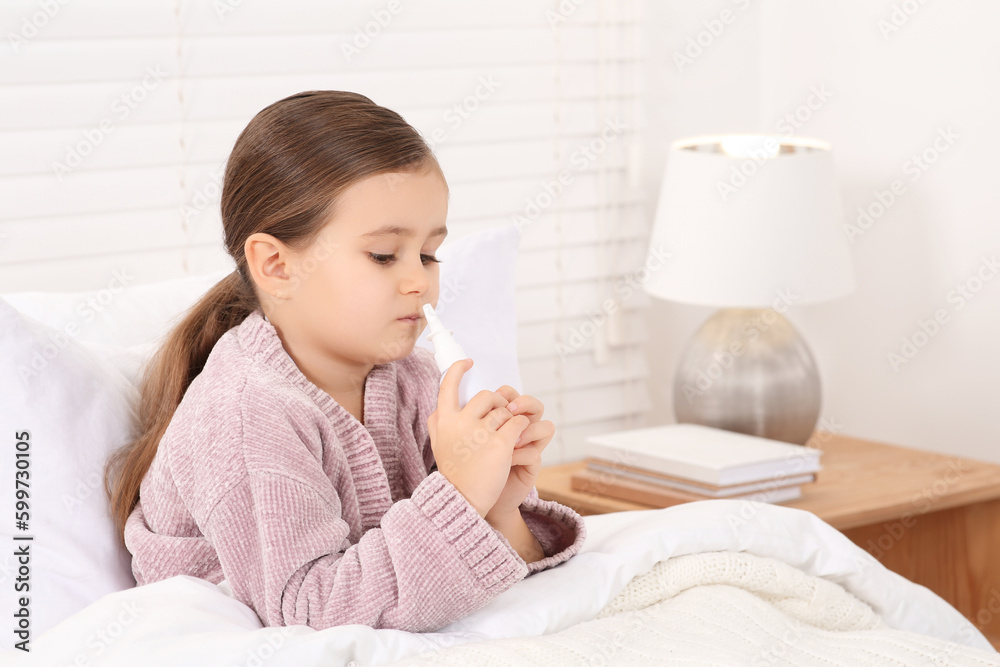 Little girl using nasal spray in bedroom Little girl using nasal spray in bedroom