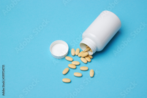Pills with bottle on a blue