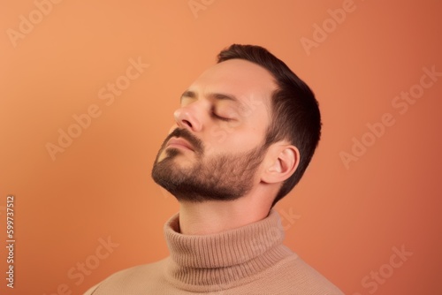 Portrait of a young man with closed eyes on a orange background