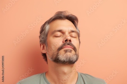 Portrait of a handsome man with gray hair and beard on a pink background
