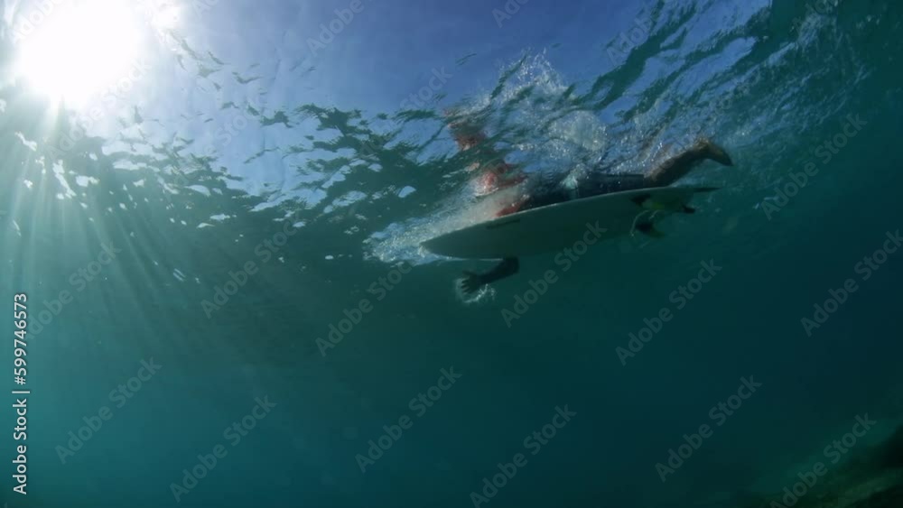 Slow Motion Shot Of Man Swimming With Surfboard Seen From Undersea - Oahu, Hawaii Slow Motion Shot Of Man Swimming With Surfboard Seen From Undersea - Oahu, Hawaii