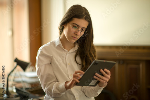 businesswoman working in office and making analysis and phone call with tablet