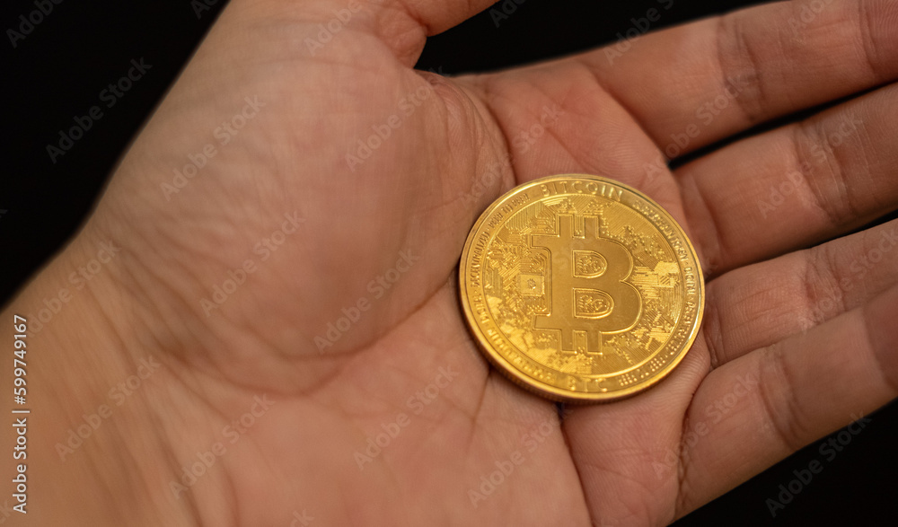hand of a businessman holding bitcoin, symbol of future saving or investment bitcoin will become gold in the future hand of a businessman holding bitcoin, symbol of future saving or investment bitcoin will become gold in the future