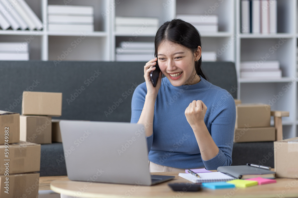 Asian business woman on sofa using a laptop computer checking customer order online shipping boxes at home. Starting SME Small business entrepreneur freelance. Online business, SME Work home concept.
Asian business woman on sofa using a laptop computer checking customer order online shipping boxes at home. Starting SME Small business entrepreneur freelance. Online business, SME Work home concept.