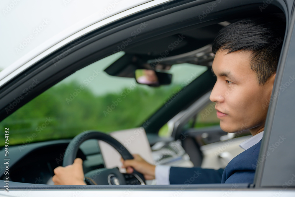 Asian handsome young man with good mood Smiling happy drove his new white car. Asian man buys a new car Asian handsome young man with good mood Smiling happy drove his new white car. Asian man buys a new car