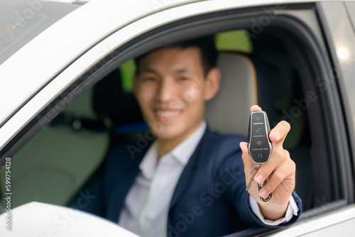 focus on car keys A handsome young man in a good mood holding the keys to his new car with a smile. Asian man with car keys in hand. concept of having a new car © เลิศลักษณ์ ทิพชัย