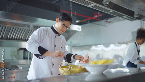 Male asian chef working at kitchen, He cooking food for customer. Chef, Lifestyle, Working, Teamwork and Chef table concept.