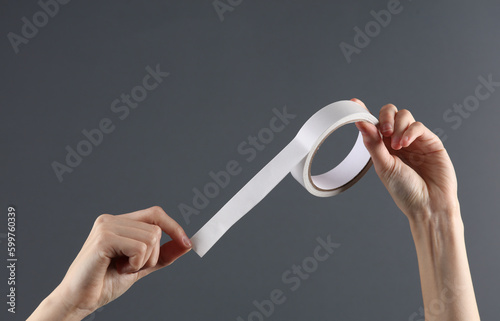 Foto Hand holding duct tape on gray background