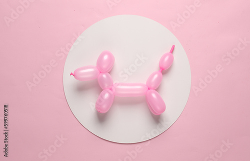 Inflatable balloon dog on in white circle on pink background. Creative layout