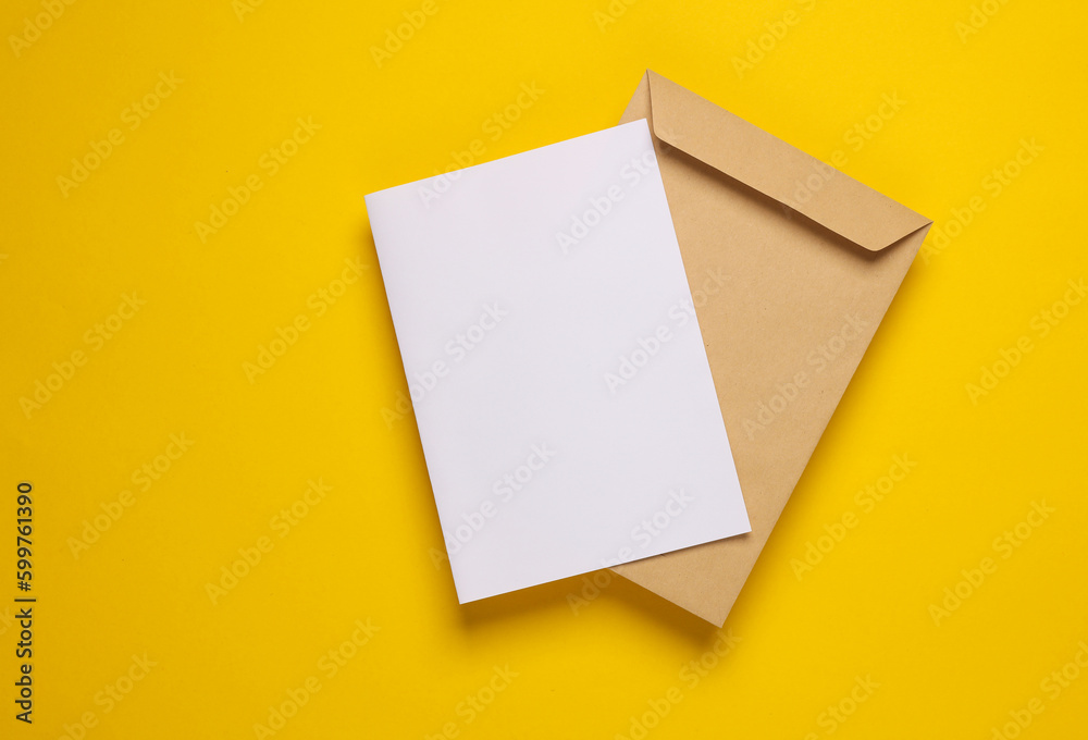 Craft postal envelope with white blank letter on yellow background