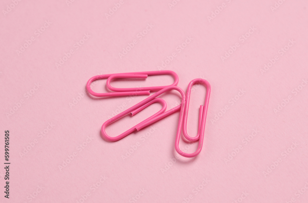 Pink paper clips on pink background Pink paper clips on pink background
