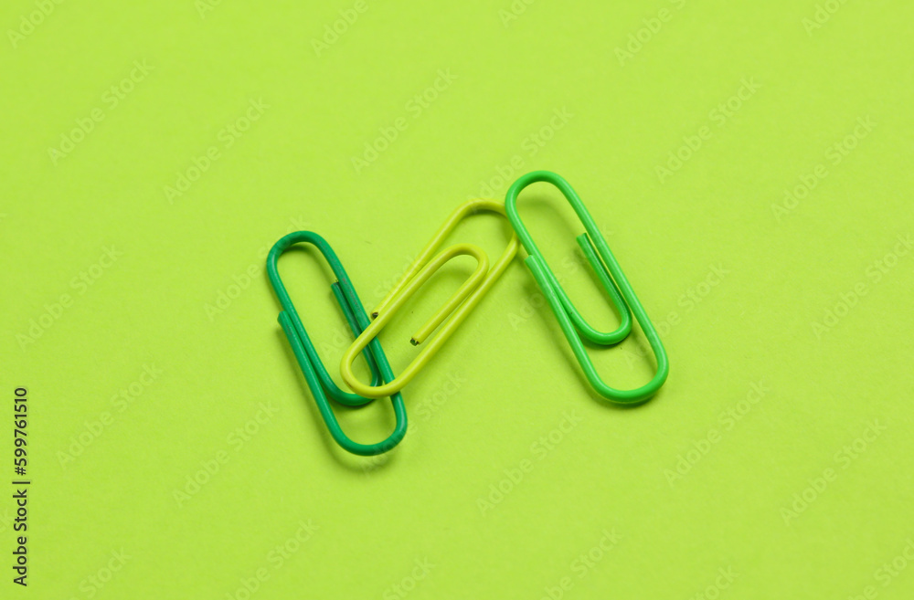 Pink paper clips on green background Pink paper clips on green background