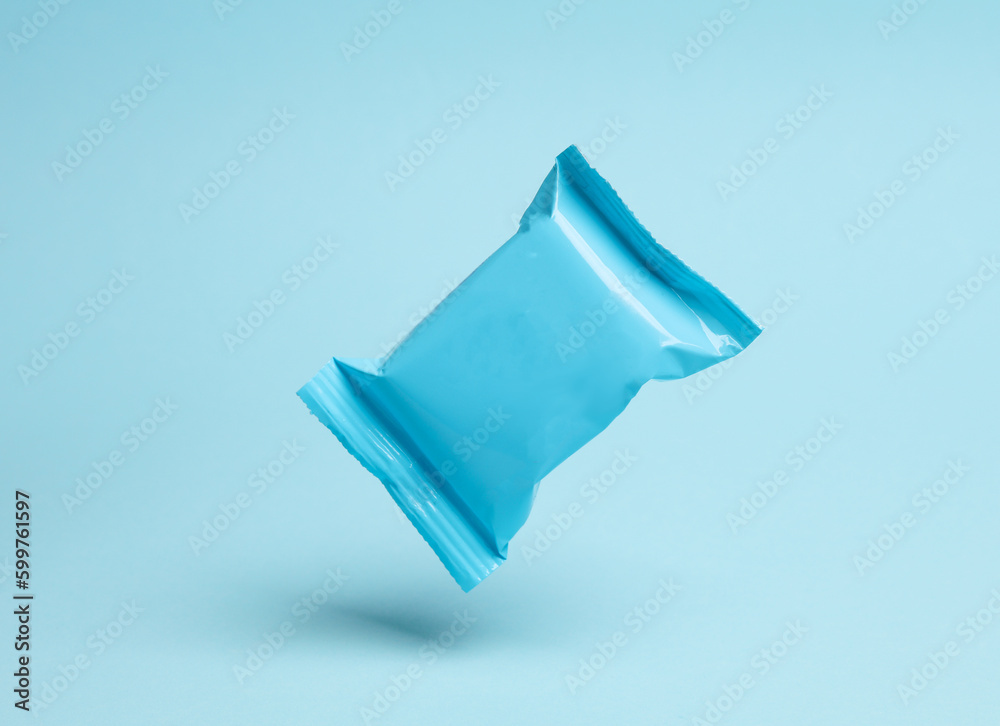 Blue candy packaging levitating on blue background with shadow. Blue candy packaging levitating on blue background with shadow.