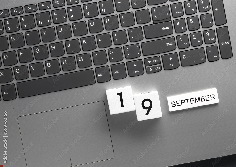 White wooden block calendar with date september 19 on laptop keyboard. Business, deadline, planning White wooden block calendar with date september 19 on laptop keyboard. Business, deadline, planning