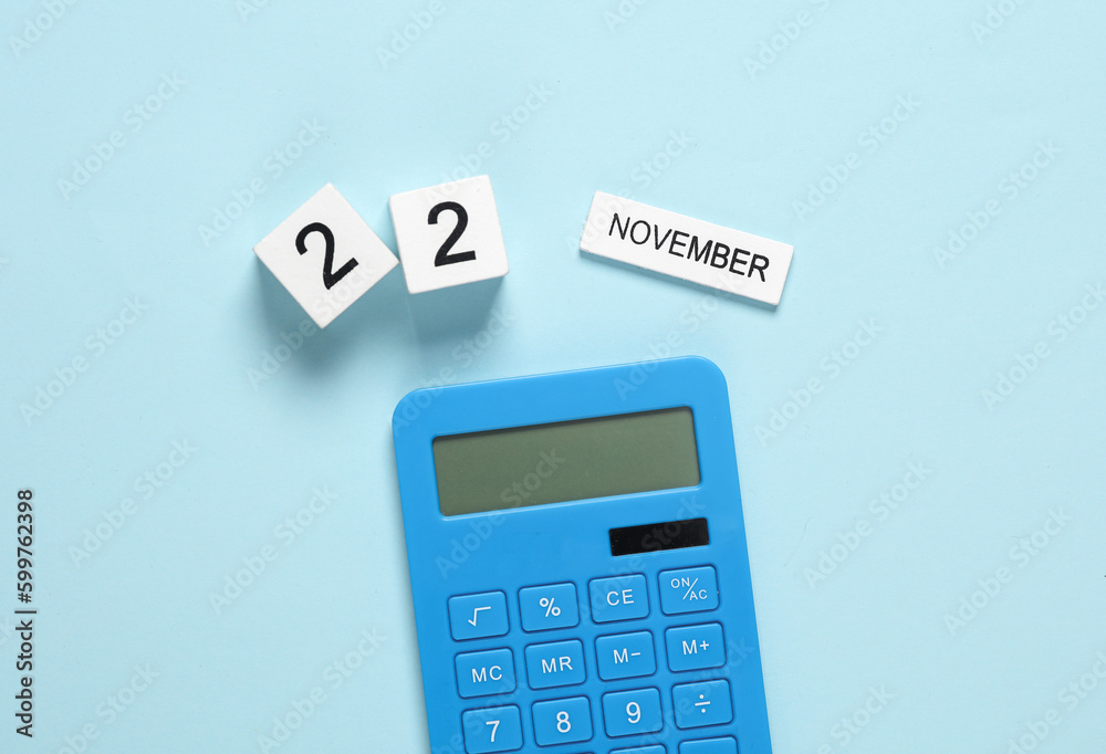 Business concept, planning, deadline. Calendar with the date november 22 and calculator on a blue background. Business concept, planning, deadline. Calendar with the date november 22 and calculator on a blue background.