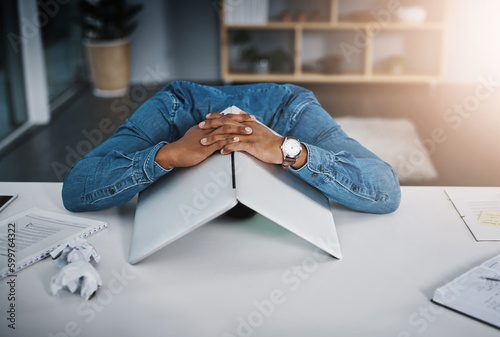 Businessman, frustrated and laptop covering head in office and tired, depressed employee sleeping on desk. Man, work and stress or burnout, problem or technology fail, workload and headache