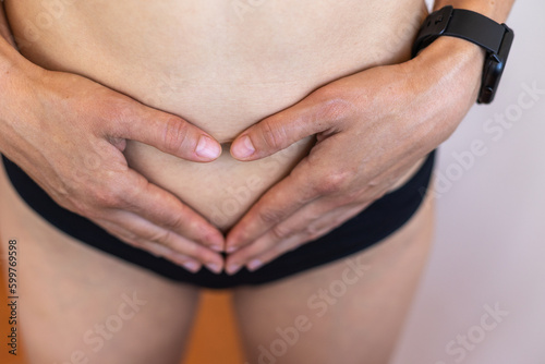 healthy woman making a heart symbol on her buttonhole outdoors. childbirth preparation.