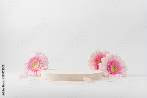 Fototapeta Naklejka Na Ścianę i Meble -  Wooden round podium pedestal cosmetic beauty product presentation empty mockup on  white background with gerbera flowers