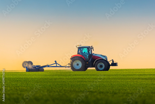 Tractor with a roller tillage on spring field. Soil rolling supports germination and is the basis for good harvesting, organic farming and agronomy