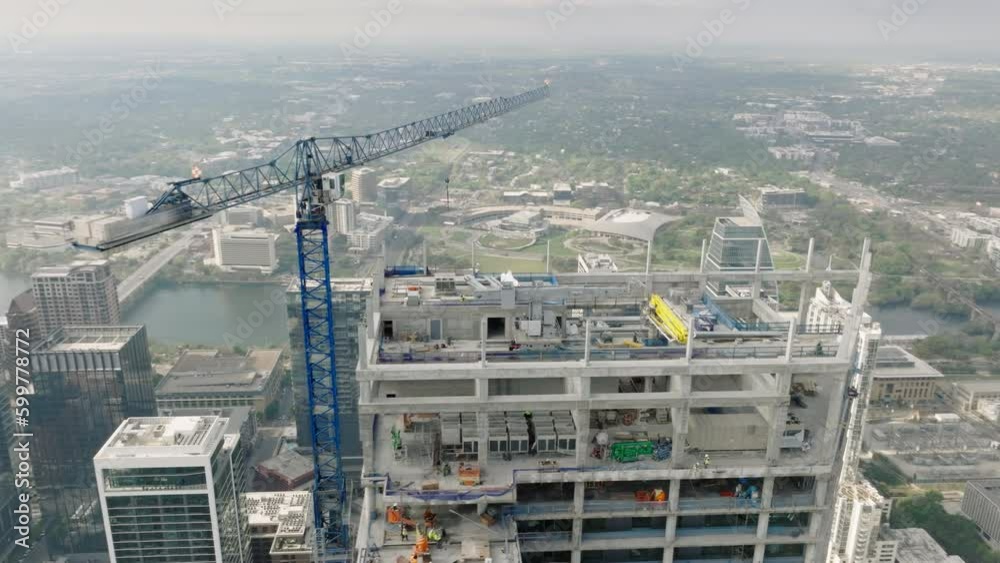 Aerial Austin Texas USA. Construction site aerial view of crane working on building in industrial district. Modern architecture development with scenic Austin downtown view on motion background 4K Aerial Austin Texas USA. Construction site aerial view of crane working on building in industrial district. Modern architecture development with scenic Austin downtown view on motion background 4K